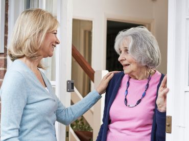 Middle aged woman talking to elderly female neighbor