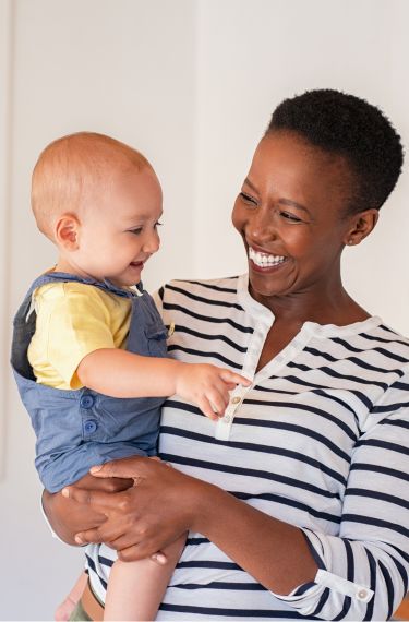 woman smiling and holding a baby