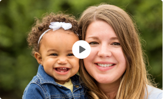 Mom and toddler daughter smiling at camera