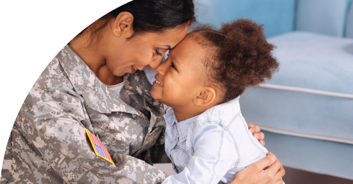 Military mother in uniform with head tilted toward young daughter