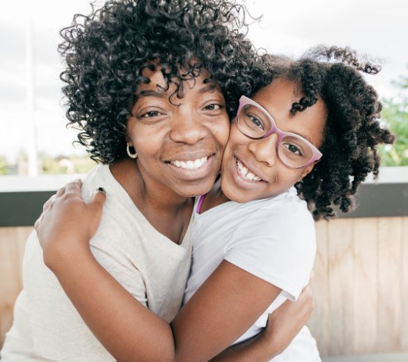 Mom hugging her school-aged daughter