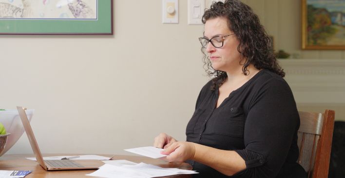 Woman sitting at a table opening mail