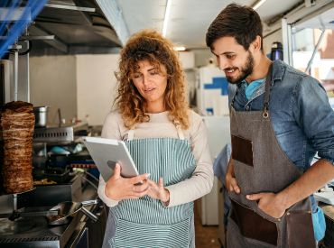 Man and woman in a kitchen looking at a tablet