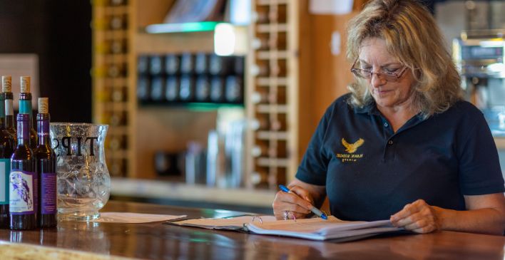 Female worker in a winery writing in a notebook