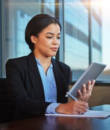 Female worker holding a tablet and writing in a notebook