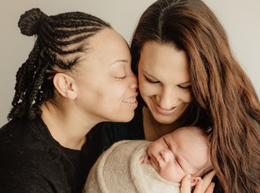 Female couple holding newborn baby