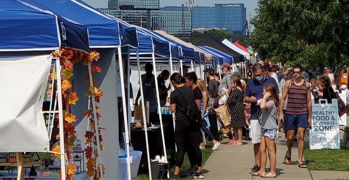Festival with vendor tents and people walking around